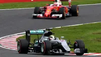 Pebalap Mercedes, Lewis Hamilton, mengungguli pebalap Ferrari, Sebastian Vettel, dalam balapan F1 GP Jepang di Sirkuit Suzuka, Jepang, Minggu (9/10/2016). (AFP/Toshifumi Kitamura)