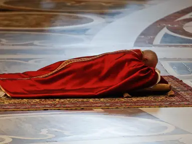 Paus Fransiskus berdoa sambil berbaring di lantai dalam prosesi Jumat Agung memperingati penyiksaan Yesus sebelum disalibkan di Basilika Santo Petrus, Vatikan, Jumat (19/4). (AP Photo/Alessandra Tarantino)