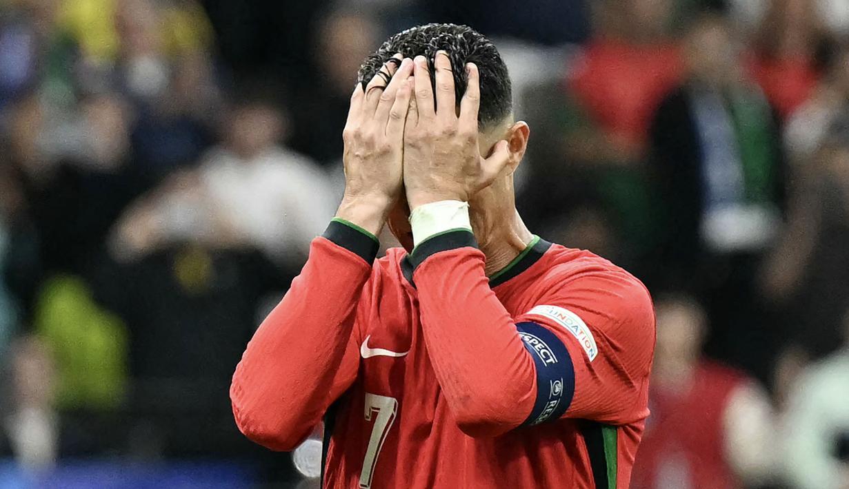 Pemain Portugal, Crsitiano Ronaldo, tampak kecewa setelah gagal mencetak gol penalti saat melawan Slovenia pada babak 16 besar Euro 2024 di Frankfurt Arena, Selasa (2/7/2024). (AFP/Patricia De Melo Moreira)