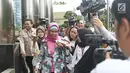 Direktur Produksi PT Garuda Indonesia Puji Nur Handayani menghindari awak media seusai pemeriksaan di Gedung KPK, Rabu (21/3). Selain Puji, tim penyidik juga memanggil pensiunan pegawai Garuda Indonesia Capt Agus Wahjudo. (Liputan6.com/Herman Zakharia)