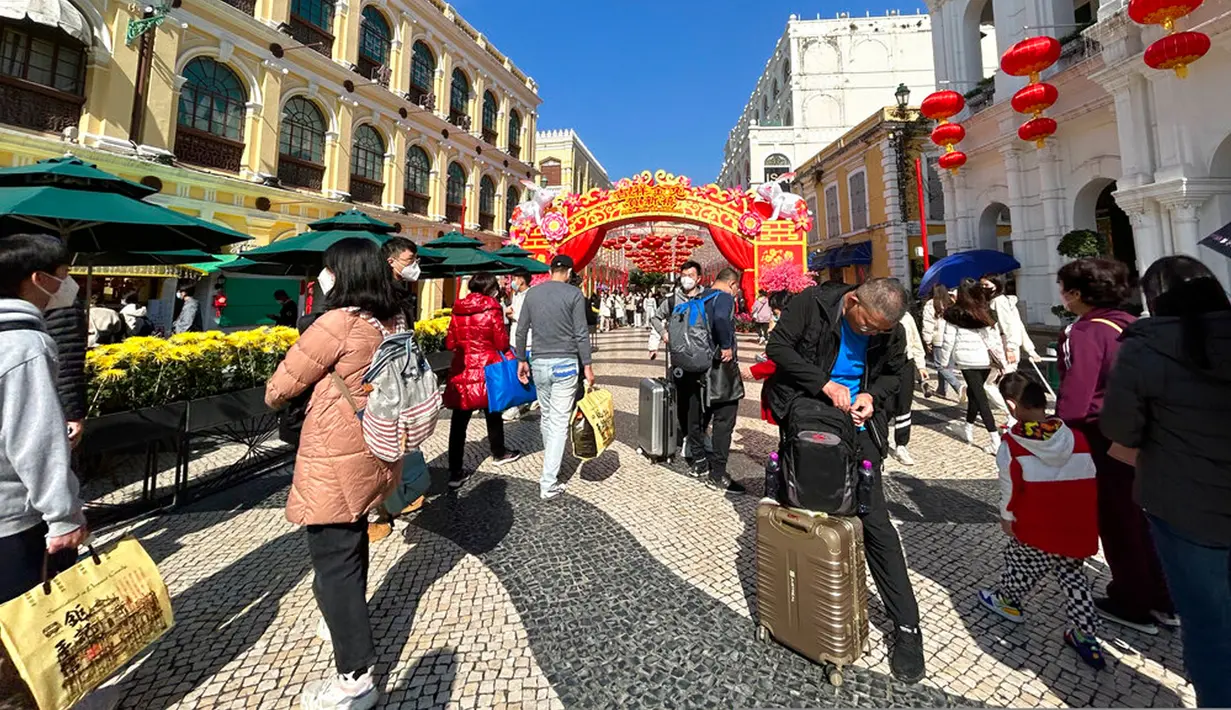 Pelancong dari China daratan berjalan di sekitar Lapangan Senado, tujuan wisata di Makau, 18 Januari 2022. Ledakan pariwisata China yang diharapkan selama liburan Tahun Baru Imlek minggu depan tampaknya akan lebih cepat terjadi. (AP Photo/Kanis Leung)