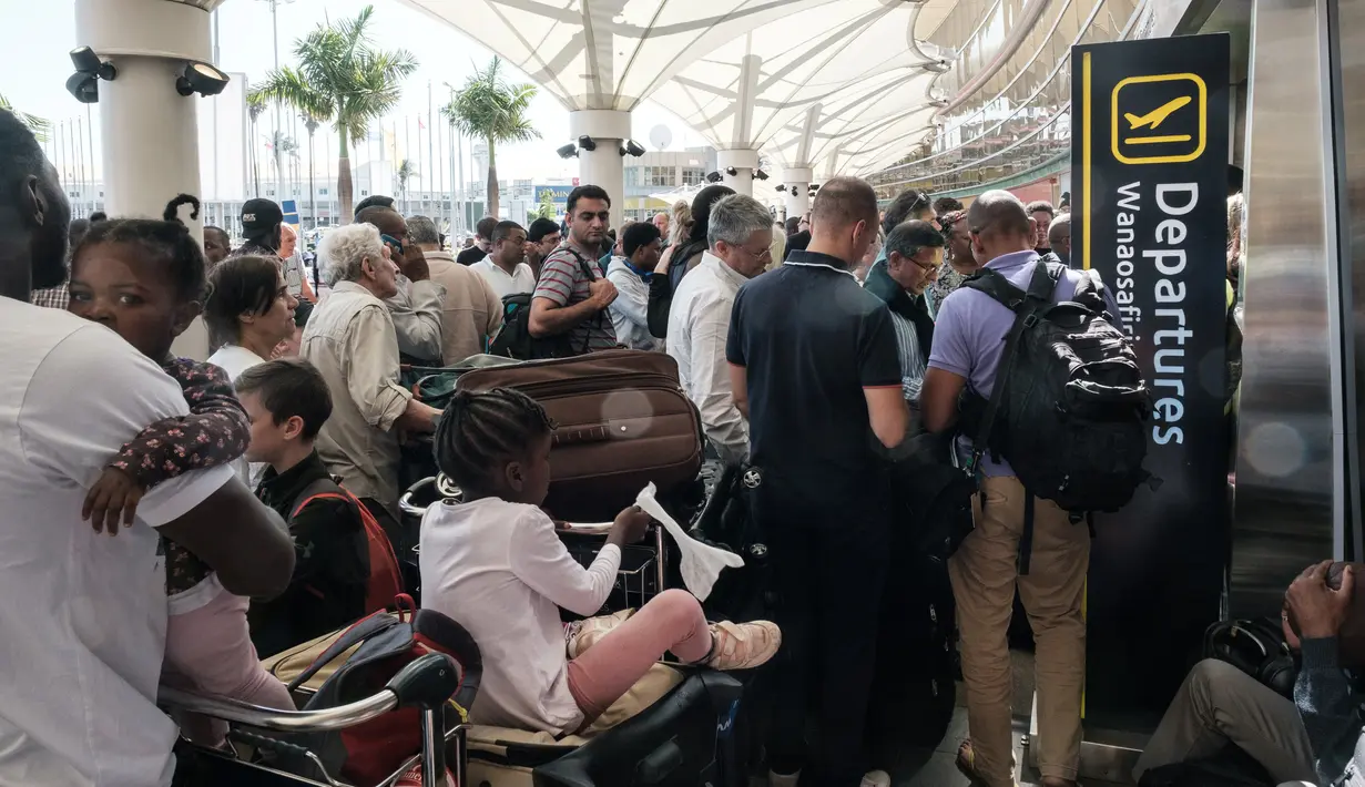 Penumpang menunggu di luar terminal keberangkatan Kenya Airways  setelah pemogokan pekerja maskapai di Bandara Internasional Jomo Kenyatta, Nairobi, Rabu (6/3). Aksi itu menyebabkan pembatalan dan penundaan sejumlah penerbangan. (Yasuyoshi CHIBA/AFP)