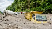 Truk milik penambang pasir tertimbun abu vulkanik setelah hujan deras mengguyur lereng Gunung Merapi di Magelang, 2 Desember 2021. Sejumlah truk tambang tertimbun lahar dingin Gunung Merapi. (AGUNG SUPRIYANTO/AFP)