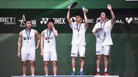 Pasangan Jepang Hiroyuki Endo/Yuta Watanabe dan pasangan Indonesia Kevin Sanjaya Sukamuljo/Marcus Fernaldi Gideon berdiri di podium usai laga final ganda putra All England 2020 di Birmingham, Inggris, Minggu (15/3/2020). Kevin/Marcus kalah dengan skor 18-21, 21-12, dan 19-21. (Oli SCARFF/AFP)