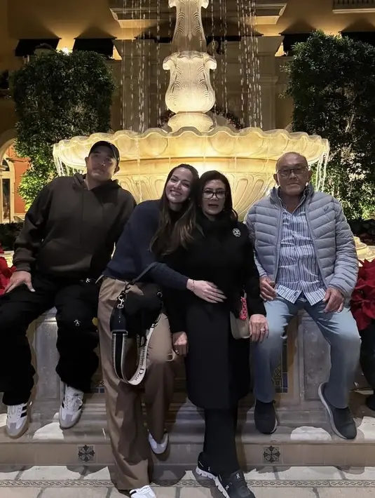 Bersama mertuanya, Nia mengenakan atasan sweater hitam dipadukan celana coklat loose dan sneakers Adidas. Sambil membawa tas hitam Dior. [@ramadhaniabakrie]