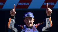 Pembalap Spanyol Repsol Honda, Marc Marquez mengangkat kedua tangan setelah memenangkan balapan seri ke 18 MotoGP Grand Prix Valencia di Sirkuit Ricardo Tormo, Valencia (12/11). Marquez mengantongi gelar juara keenam kalinya. (AFP PHOTO / Jose Jordan)