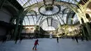 Orang-orang  berseluncur di arena ice skating di bawah kubah kaca mewah legendaris, Grand Palais, Paris, Senin (17/12). Arena ice skating musiman ini terbuka untuk umum selama liburan Natal. (AP Photo/Christophe Ena)