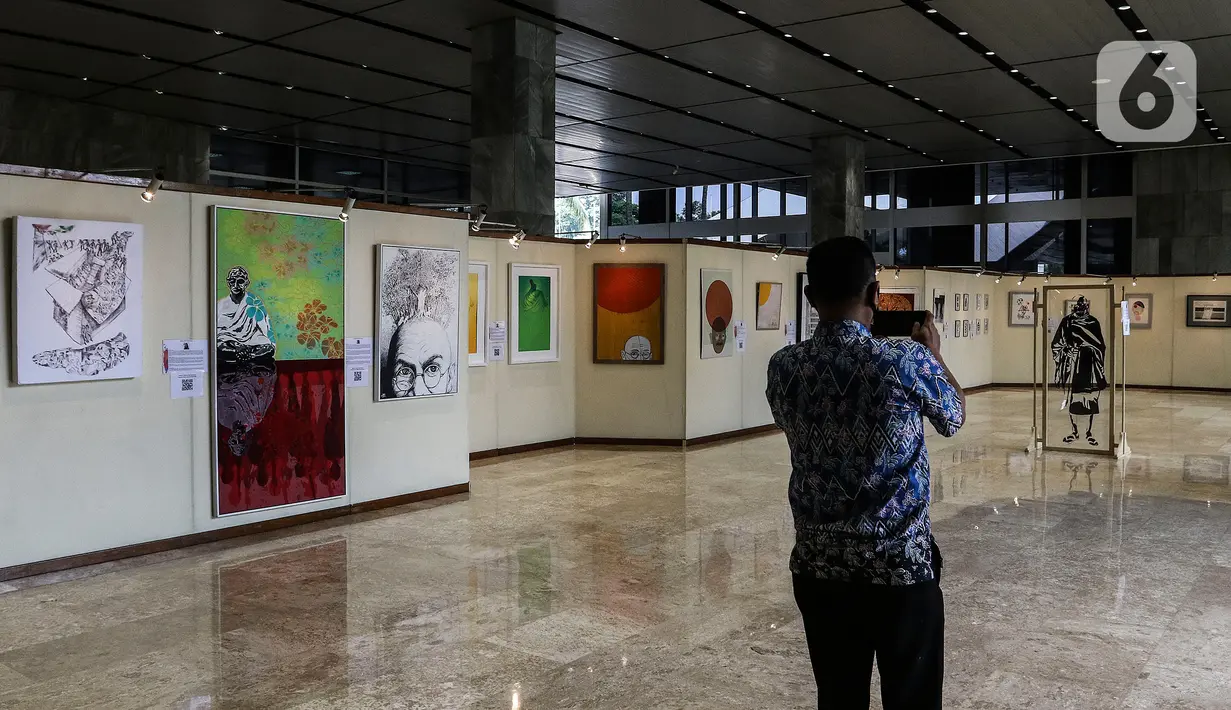Pengunjung melihat karya lukis dan karya foto pada pameran 150 Tahun Mahatma Gandhi di kompleks Parlemen, Senayan, Jakarta, Jumat (2/10/2020). Dalam pameran ini juga memperingati 150 tahun hari kelahiran Mahatma Gandhi serta Peringatan Hari Anti Kekerasan Dunia. (Liputan6.com/Johan Tallo)