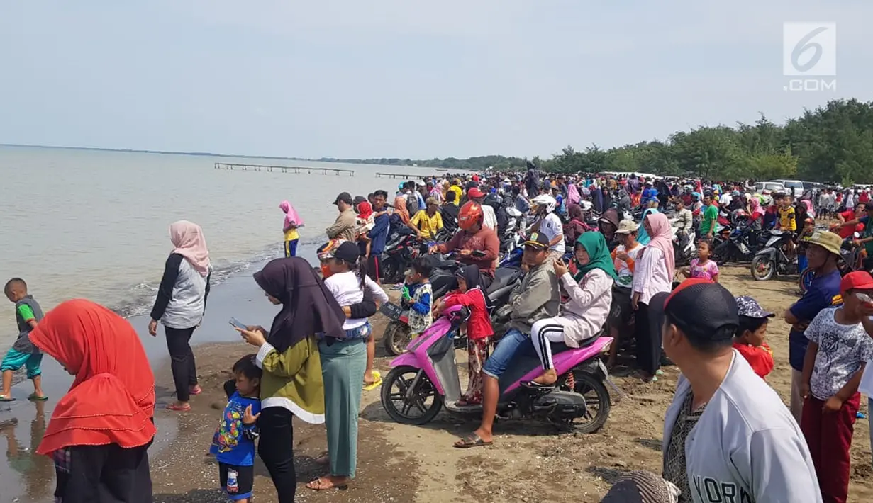 Warga berkerumun menantikan evakuasi pesawat Lion Air JT 610 di Pantai Pakis Jaya, Karawang, Jawa Barat, Senin (29/10). Warga yang penasaran berduyun-duyun datang ke pantai dekat lokasi jatuhnya pesawat. (Liputan6.com/Herman Zakharia)