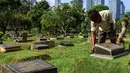 Petugas merawat makam di Tempat Pemakaman Umum (TPU) Karet Bivak, Jakarta, Selasa (11/5/2021). Pemprov DKI akan memberlakukan larangan ziarah kubur Idulfitri di seluruh TPU mulai 12 hingga 16 Mei untuk mencegah terjadinya penyebaran Covid-19 saat berkumpul untuk berziarah. (Liputan6.com/JohanTallo)