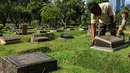 Petugas merawat makam di Tempat Pemakaman Umum (TPU) Karet Bivak, Jakarta, Selasa (11/5/2021). Pemprov DKI akan memberlakukan larangan ziarah kubur Idulfitri di seluruh TPU mulai 12 hingga 16 Mei untuk mencegah terjadinya penyebaran Covid-19 saat berkumpul untuk berziarah. (Liputan6.com/JohanTallo)