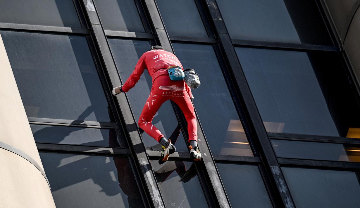 Alain Robert, pendaki bangunan pencakar langit asal Prancis memanjat Menara Montparnasse di Paris, Prancis, Rabu (12/10/2022). Alain Robert yang dikenal sebagai Spiderman Prancis itu kembali beraksi dengan memanjat Menara Montparnasse yang memiliki ketinggian 210 meter. (Bertrand GUAY/AFP)