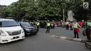 Petugas polisi mengatur lalu lintas saat pemberlakuan sistem ganjil genap di pintu masuk Gardu Tol Cibubur 2, Jakarta, Senin (16/4). Kebijakan ini diterapkan untuk mengurai kemacetan di ruas Tol Jagorawi. (Liputan6.com/Faizal Fanani)
