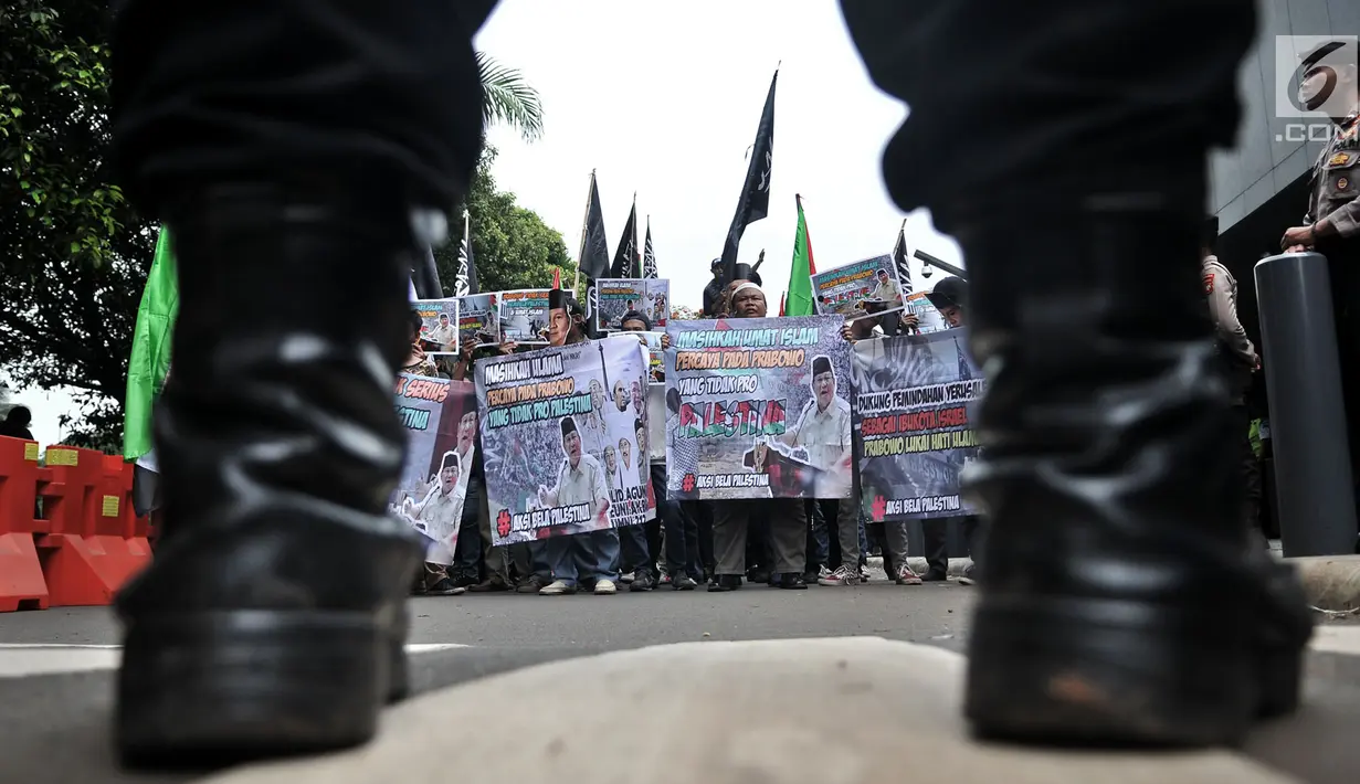 Massa yang tergabung dalam Gema Muslim Indonesia (GMI) membentangkan poster dan mengibarkan bendera Palestina saat berunjuk rasa di depan Kedutaan Besar Australia, Jakarta, Senin (26/11). (Liputan6.com/Iqbal S Nugroho)