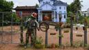 Orang-orangan sawah diikat ke pagar di depan sebuah rumah di provinsi Kampong Cham, Kamboja, 11 Oktober 2020. Para petani di desa itu menggunakan orang-orangan sawah atau disebut juga Tim Mong untuk menangkal virus corona  Covid-19 berdasarkan kepercayaan yang mereka yakini. (TANG CHHIN Sothy/AFP)