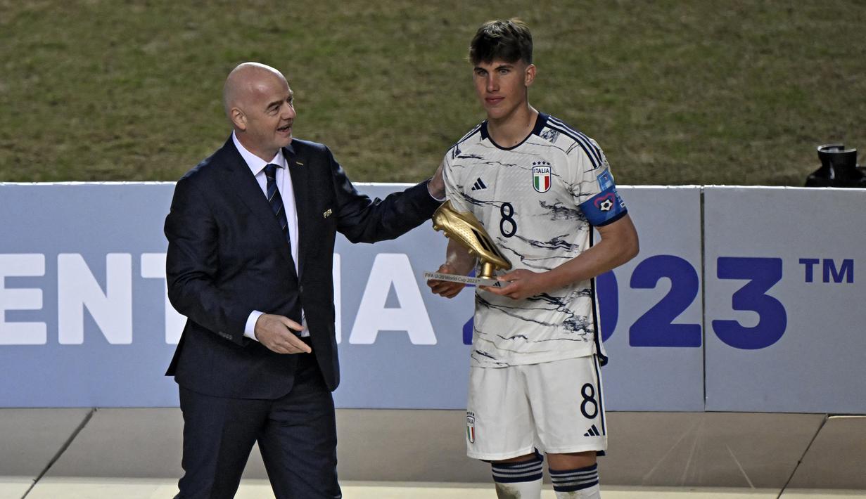 Presiden FIFA, Gianni Infantino (kiri) menyerahkan trofi Golden Boot Award kepada gelandang Italia, Cesare Casadei setelah laga final Piala Dunia U-20 2023 antara Uruguay menghadapi Italia di Unico Diego Armando Maradona Stadium, La Plata, Argentina, Senin (12/6/2023) dini hari WIB. Cesare Casadei dinobatkan sebagai top skor turnamen dengan total mencetak 7 gol. (AFP/Luis Robayo)