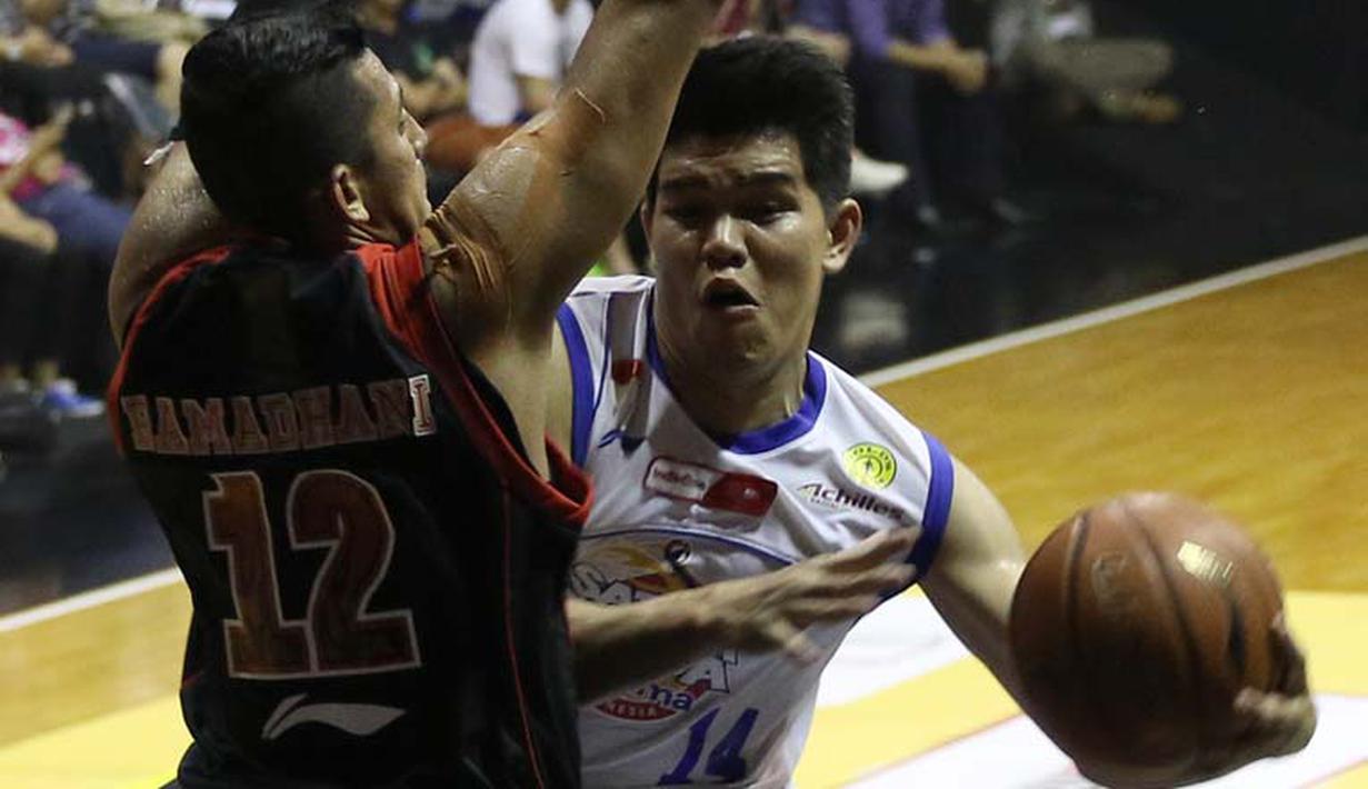 Pemain Satria Muda Britama, Christmas Bonanza Siregar, berusaha melewati hadangan pemain Aspac, Fandi Andika Ramadhani, dalam lanjutan pertandingan basket NBL Championship Series di Hall Basket Gelora Bung Karno, Senin (4/5). (bola.com/Arief Bagus)