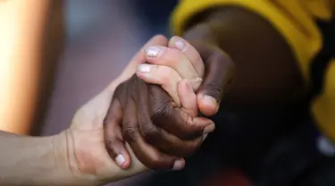 Orang-orang bergandengan tangan saat demonstrasi memprotes kematian George Floyd di Barcelona, ​​Spanyol, Kamis (4/6/2020). George Floyd, seorang pria kulit hitam meninggal setelah ditahan oleh petugas kepolisian Minneapolis pada 25 Mei. (AP Photo/Emilio Morenatti)