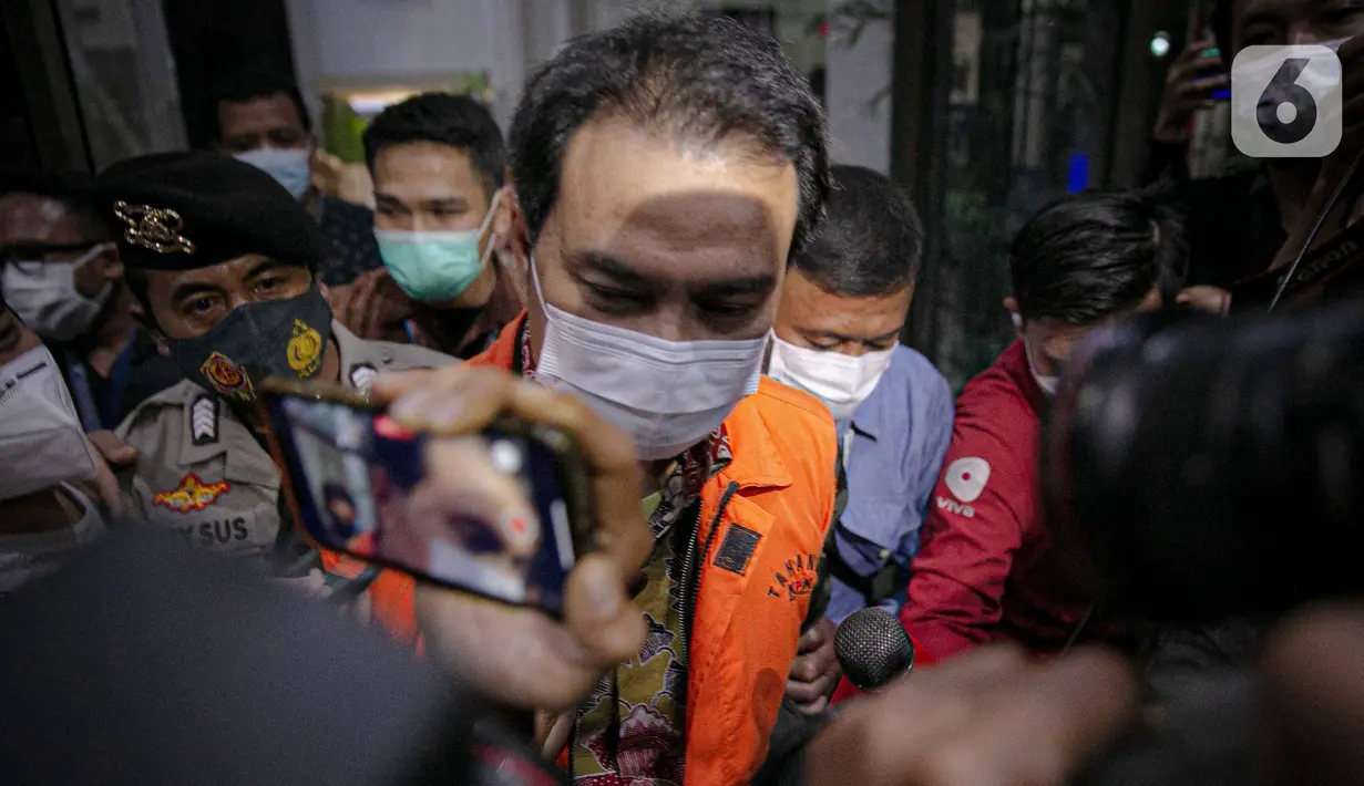 Wakil Ketua DPR Aziz Syamsuddin meninggalkan Gedung KPK untuk menuju mobil tahanan di Jakarta, Sabtu (25/9/2021). Politisi Partai Golkar ini ditetapkan sebagai tersangka dan langsung ditahan KPK terkait kasus penanganan perkara di Kabupaten Lampung Tengah. (Liputan6.com/Faizal Fana
