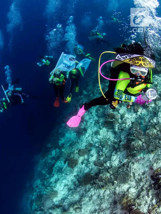 Ketua Umum Wanita Selam Indonesia (WASI), Tri Suswati Karnavian didampingi Nadine Chandrawinata dan 8 penyelam wanita membawa api obor Asian Games 2018 di perairan Pulau Piaynemo, Raja Ampat, Papua Barat, Kamis (26/7). (Liputan6.com/HO/Mabes Polri)
