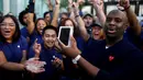 Pelanggan merayakan keberhasilannya mendapatkan iPhone 7 dengan pekerja Apple di sebuah toko Apple Inc di New York, AS, Jumat (16/9). Pembeli iPhone7 hari ini menjadi bagian dari pembeli pertama di seluruh dunia. (REUTERS / Eduardo Munoz)
