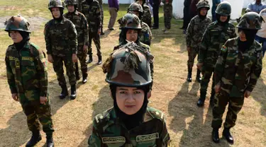 Para kadet perempuan Afghanistan berdiri dalam formasi selama sesi latihan militer di Chennai, Rabu (19/12). Sembilan belas kadet tentara Afghanistan perempuan mengambil bagian dalam program pelatihan militer India. (ARUN SANKAR / AFP)