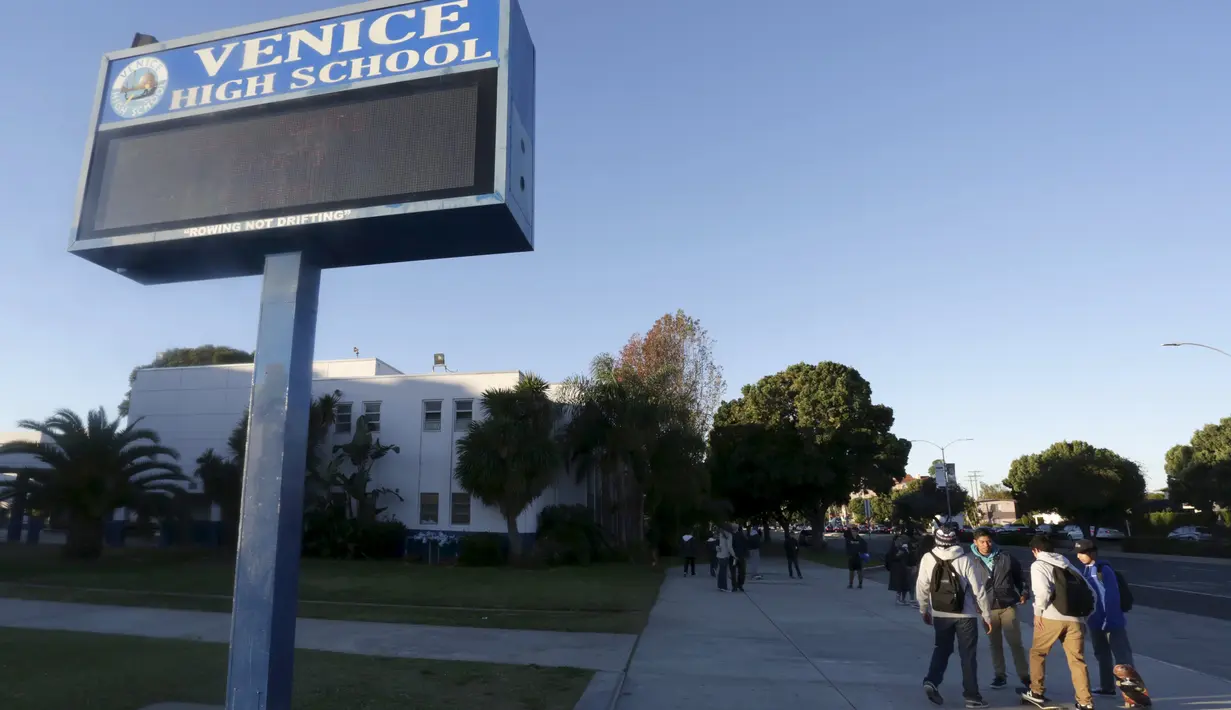 Para siswa berdiri di luar SMA Venice di Los Angeles, Selasa (15/12). Seluruh sekolah di distrik Los Angeles, Amerika Serikat, ditutup pada hari Selasa setelah pihak berwenang dikabarkan mendapat ancaman. (REUTERS/Jason Redmond)