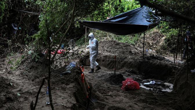 Seorang peneliti bekerja di kuburan massal rahasia di negara bagian Veracruz, Meksiko, Jumat (7/9). Jasad-jasad itu diduga kuat sebagai korban perang antargeng narkoba serta kekerasan terkait meningkatnya ekskalasi akibat kasus korupsi. (AP/Felix Marquez)