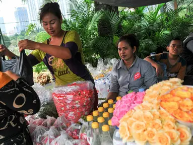 Penjual kembang melayani pembeli yang hendak ziarah ke makan keluarganya di TPU Karet Bivak, Jakarta, Minggu (29/5/2016). Pedagang kembang untuk keperluan ziarah mulai ramai jelang memasuki bulan Ramadan 2016. (Liputan6.com/Yoppy Renato)