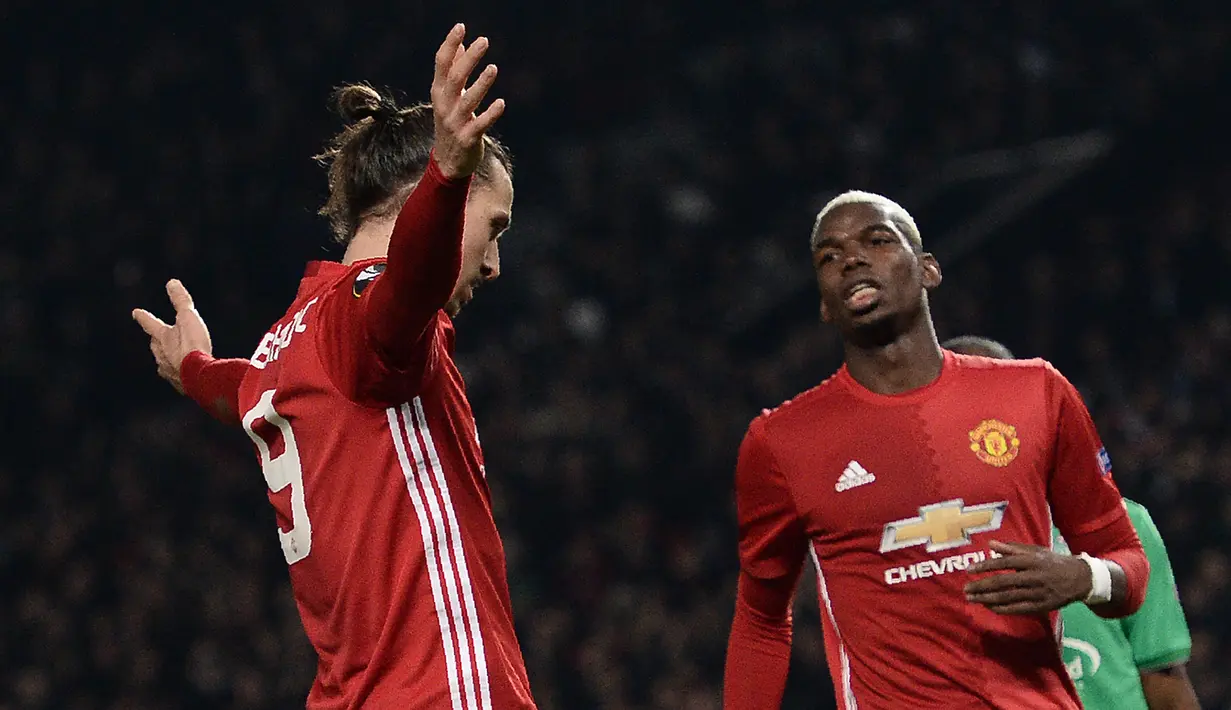 Zlatan Ibrahimovic melakukan selebrasi bersama Paul pogba usai mencetak gol ke gawang Saint-Etienne dalam laga Liga Eropa di Olad Trafford, Inggris, (16/2). Ibrahimovic memborong tiga gol di pertandingan ini. (AFP Photo / Oli Scarff)