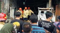 Petugas mengevakuasi korban kebakaran pom mini di Sidoarjo. (Dian Kurniawan/Liputan6.com).