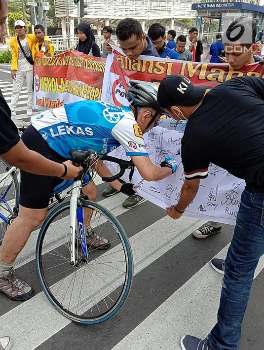 Masyarakat menandatangi spanduk petisi menolak gerakan people power saat car free day (CFD) di kawasan Thamrin, Jakarta, Minggu (19/5/2019). Aliansi Mahasiswa dan Pemuda Cinta NKRI mengajak masyarakat menandatangani petisi mendukung KPU dan Bawaslu pasca Pilpres 2019. (Liputan6.com/Faizal Fanani)