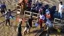 Rakit tali darurat tersebut menjadi alat penghubung utama bagi warga yang berada di dua sisi sungai untuk aktivitas ekonomi, pendidikan, serta keperluan sehari-hari. Tampak dalam foto, snak-anak turun dari rakit di sepanjang sungai Peusangan setelah banjir bandang yang menghancurkan desa-desa di sekitarnya di Kabupaten Bireuen, provinsi Aceh, pada Senin 5 Januari 2026. (CHAIDEER MAHYUDDIN/AFP)