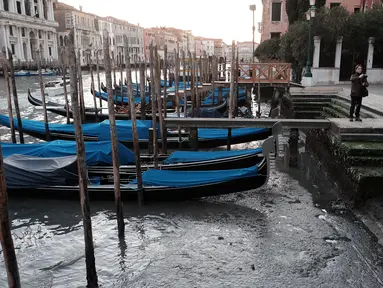 Sejumlah perahu Gondola bersandar di tengah surutnya Grand Canal di laguna Venesia, Italia (29/12). Surutnya kanal ini mengakibatkan Gondola sulit berjalan dan banyak bersandar di pinggir Grand Canal di laguna Venesia, Italia. (REUTERS/Manuel Silvestri)