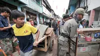 Seorang warga menggunakan gerobak untuk mengemasi perabotan miliknya saat penertiban kawasan Bukit Duri, Jakarta, Rabu (28/9). Sedikitnya 400 petugas gabungan bersiaga di wilayah Bukit Duri yang terdampak penggusuran. (Liputan6.com/Yoppy Renato)