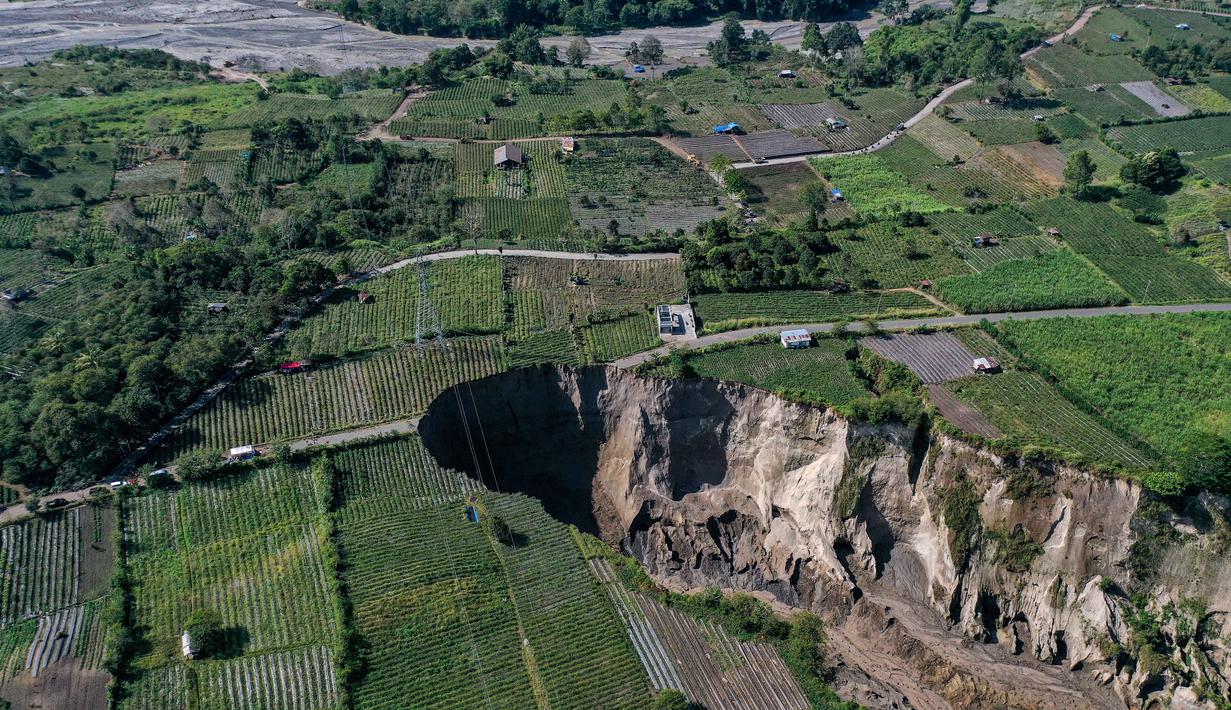 Foto udara menunjukkan lokasi longsor di Desa Pondok Balik, Kecamatan Ketol, Aceh Tengah, provinsi Aceh pada 1 Februari 2026. Fenomena longsor berupa lubang raksasa (sinkhole) di Desa Pondok Balik, Kecamatan Ketol, Aceh Tengah, terus meluas dan berada dalam kondisi kritis. (Fadly/AFP)