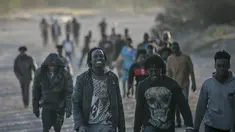 Para migran tiba di tanah Spanyol setelah melintasi pagar yang memisahkan kantong Spanyol Melilla dari Maroko, di Melilla, Spanyol (3/3/2022). Ratusan orang Afrika mencoba memanjat pagar yang memisahkan kota Melilla di Spanyol dari Maroko untuk hari kedua berturut-turut. (AP Photo/Javier Bernardo)