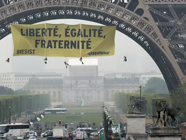 Sebuah spanduk bertuliskan "Kebebasan, Kesetaraan, Persaudaraan" terpampang di Menara Eiffel di Paris, Prancis, Kamis (5/5). (AFP/Jacques DEMARTHON)