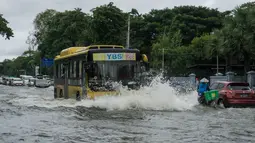 Sebuah bus melewati jalan yang banjir di pinggiran Yangon (17/8/2022). Banjir telah melanda banyak bagian negara bagian termasuk Zeya Myine, Thiri Myine, Thiri Minglar, Myain Thayar, Shwe Pyae Aye, Zeya Thiri, dan Phaekhin Wards. (AFP/Stringer)