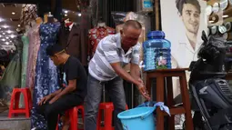 Pengunjung melakukan cuci tangan sebelum memasuki pertokoan di Pasar Baru (9/6/2020). Jelang pemberlakuan normal baru sejumlah toko di kawasan tersebut mewajibkan para pembeli untuk cuci tangan terlebih dahulu untuk menekan penyebaran Covid-19. (Liputan6.com/Angga Yuniar)
