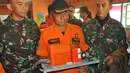 Petugas dari Basarnas memegang sebuah kotak hitam atau Black Box dari helikopter Basarnas yang jatuh di Temanggung, Jawa Tengah (3/7). Black Box tersebut akan dibawa dan dikaji oleh KNKT dan Basarnas. (AP Photo)