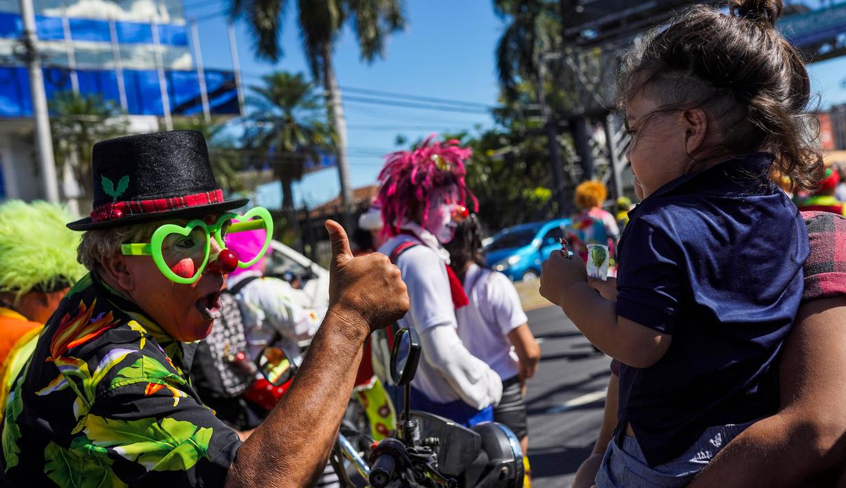 Para badut juga berinteraksi dengan seorang anak. (Camilo FREEDMAN/AFP)