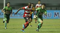 Striker Madura United, Greg Nwokolo, berebut bola dengan gelandang PS TNI, Soonhak Hong, pada laga Liga 1 Indonesia di Stadion Pakansari, Bogor, Senin (18/9/2017). Madura United menang 3-2 atas PS TNI. (Bola.com/M Iqbal Ichsan)
