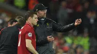 Jurgen Klopp memberikan instruksi kepada James Milner pada leg 1, babak 16 besar Liga Champions yang berlangsung di stadion Anfield, Liverpool, Rabu (20/2). Liverpool imbang 0-0 kontra Bayern Munchen. (AFP/Oli Scarff)