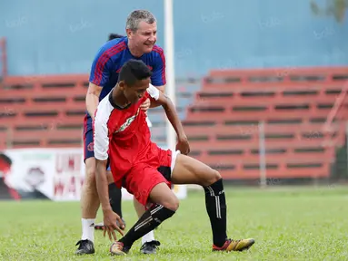 Legenda Manchester United, Denis Irwin (kanan) membantu pemain yang terjatuh pada acara United Way Coaching Clinic You C 1000 di Stadion Soemantri Brojonegoro, Jakarta, Sabtu (7/5/2016). (Bola.com/Nicklas Hanoatubun)