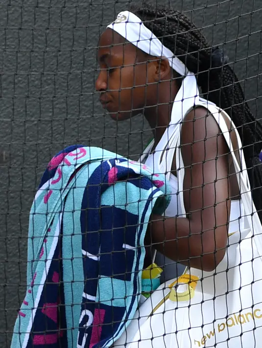 Petenis AS, Cori Gauff meninggalkan lapangan usai kalah atas petenis Rumania, Simona Halep pada babak keempat Wimbledon 2019 di All England Lawn Tennis Club, Senin (8/7/2019). Petenis berusia 15 tahun itu ditundukkan Halep, yang unggulan ke-7 turnamen, dengan skor 3-6, 3-6. (GLYN KIRK/AFP)