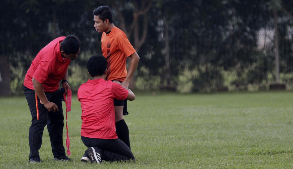 Staf pelatih Persija Jakarta memeriksa kaki Evan Dimas saat latihan di Lapangan Sutasoma, Jakarta, Rabu(28/1/2020). Gelandang Timnas Indonesia ini menjalani latihan terpisah karena masih pemulihan cedera. (Bola.com/M Iqbal Ichsan)