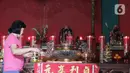 Warga keturunan Tionghoa menyalakan lilin saat sembahyang menyambut Tahun Baru Imlek 2571 di Klenteng Kong Miao, TMII, Jakarta Timur, Sabtu (25/1/2020). Perayaan imlek tahun ini merupakan tahun Tikus Logam yang melambangkan kesuburan dan kekayaan dan waktu yang baru. (Liputan6.com/Herman Zakharia)