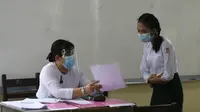 Seorang guru menjelaskan peraturan sekolah untuk mencegah penyebaran virus COVID-19 kepada siswa saat hari pendaftaran sekolah di Yangon, Myanmar (13/7/2020). Myanmar sejak Selasa (7/7) memulai pendaftaran sekolah untuk tahun ajaran 2020-2021, yang tertunda akibat pandemi COVID-19. (Xinhua/U Aung)