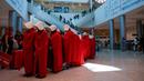 Pengunjuk rasa yang mendukung hak-hak perempuan berpakaian seperti karakter dari serial TV "The Handmaid's Tale" saat melakukan perjalanan untuk memprotes rencana pemerintah baru Perdana Menteri Benjamin Netanyahu untuk merombak sistem peradilan di sebuah stasiun kereta api di Yerusalem, Israel, 1 Maret 2023. Mengacu pada fenomena yang berkembang, harian Inggris The Guardian menggambarkan penampilan para pelayan sebagai salah satu simbol paling kuat dari protes feminis kontemporer. (AP Photo/Ohad Zwigenberg)